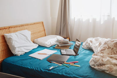 Midsection of man reading book on bed at home