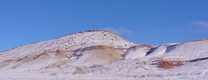 Scenic view of snowcapped mountain against blue sky