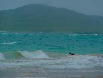 Man surfing in sea against sky