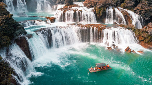 High angle view of people in boat against waterfall