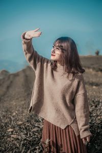 Woman standing on field against sky