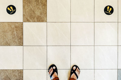 Low section of woman standing on tiled floor