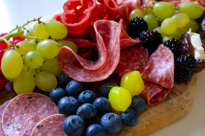 High angle view of meats and fruits in plate on table