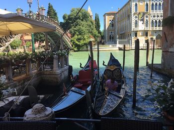 Gondolas in canal by buildings