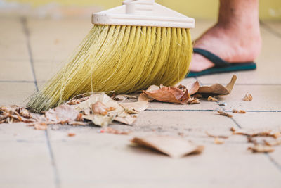 Low section of man cleaning floor with broom