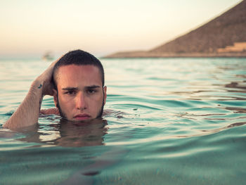 Portrait of man swimming in sea against sky