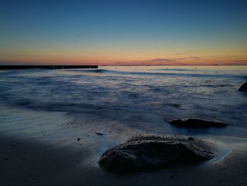 Scenic view of beach against sky during sunset