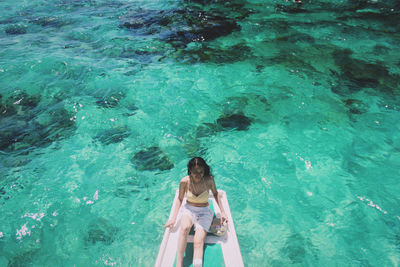 High angle view of woman sitting in boat on sea