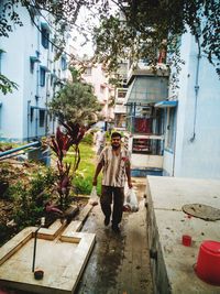 Man walking by house against building