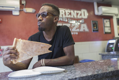 A young man eating pizza.