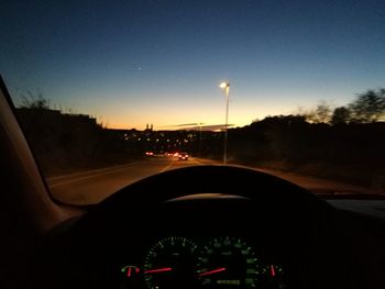 Cars on road against sky seen through car windshield