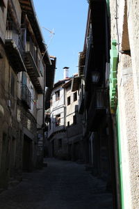 Alley amidst buildings against sky