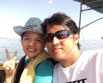 Portrait of smiling couple sitting in boat at sea