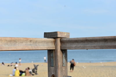 Close-up of wooden post on beach against clear sky