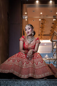 Portrait of young woman as a bride sitting on stairs 