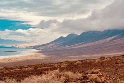 Scenic view of sea and mountains against sky