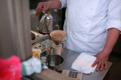 Midsection of man preparing food in cafe