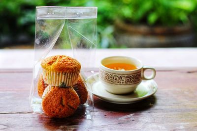 Close-up of tea with cupcakes on table