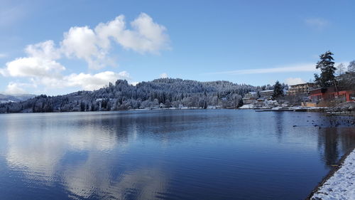 Scenic view of lake and mountains against blue sky