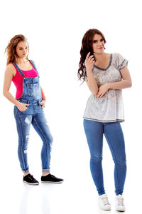 Portrait of a teenage girl standing against white background
