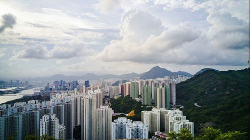 View of cityscape against cloudy sky