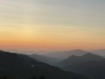 Scenic view of silhouette mountains against sky during sunset