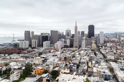 Aerial view of buildings in city against sky