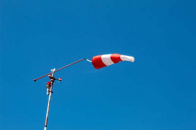 Low angle view of telephone pole against clear blue sky