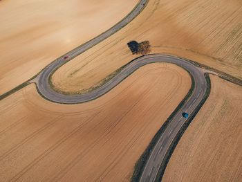 Aerial view of winding road on field