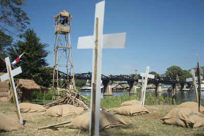 Cross shapes with jute sack against bridge over river