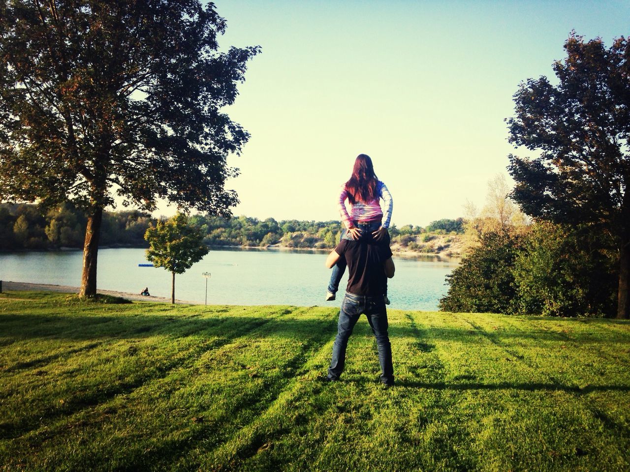 grass, tree, lifestyles, full length, leisure activity, casual clothing, field, young adult, standing, clear sky, grassy, growth, person, green color, nature, young women, tranquility, sky