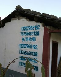 Close-up of information sign against sky