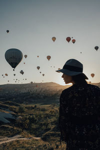 Man looking at hot air balloon against sky