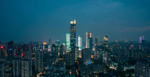 Illuminated cityscape against sky at night