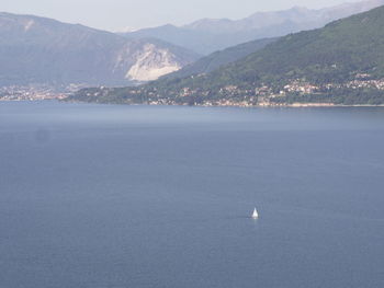 Scenic view of sea by mountains against sky