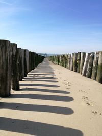 View of wooden posts in row against clear sky