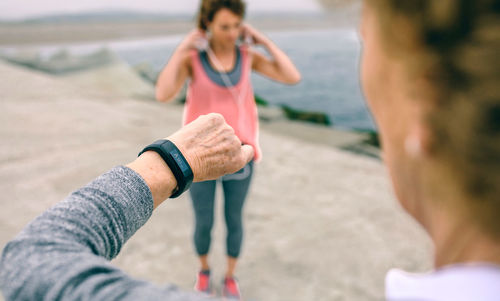 Midsection of couple holding hands on beach