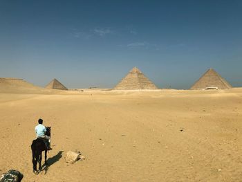 Rear view of man riding in desert