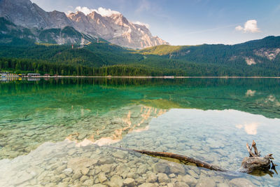 Scenic view of lake by mountains against sky