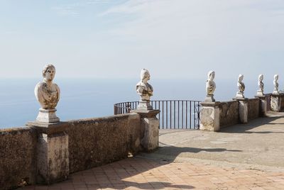 Seagull perching on statue against sky