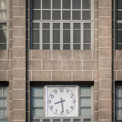 Low angle view of clock on building wall