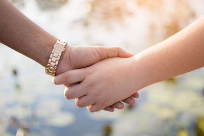 Cropped holding hands against clear sky