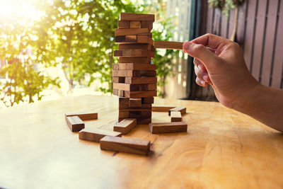 Cropped image of business person playing block removal game on table