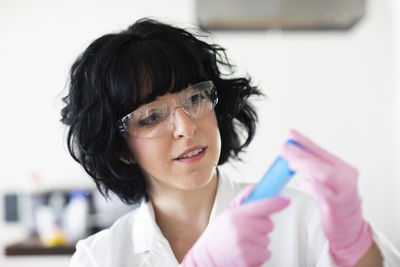 Young woman scientist portrait with gloves and safety glass