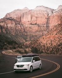 Car on road by rocky mountains