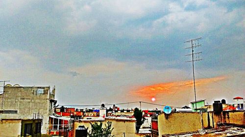 Low angle view of power lines against cloudy sky