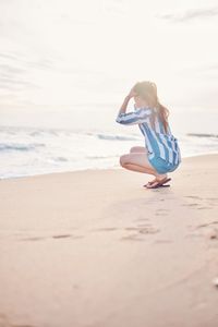 Woman enjoying at beach against sky