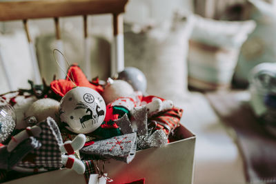 Various colorful decorative craft toys for christmas celebration in box placed in cozy room during holiday preparation