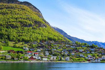 Scenic view of river by buildings against sky