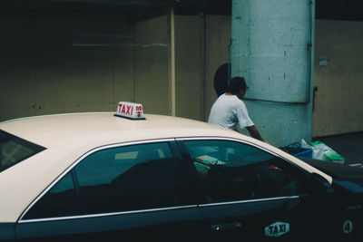 Rear view of man standing in car